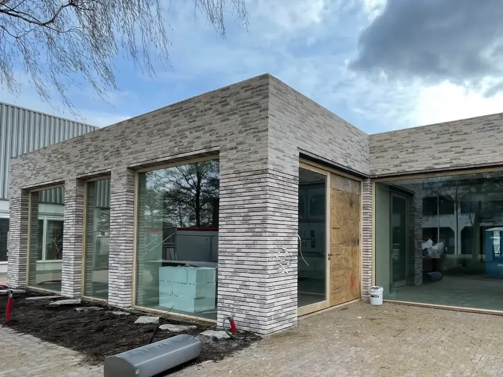 Vakman brengt isolatieplaten aan op een gevel