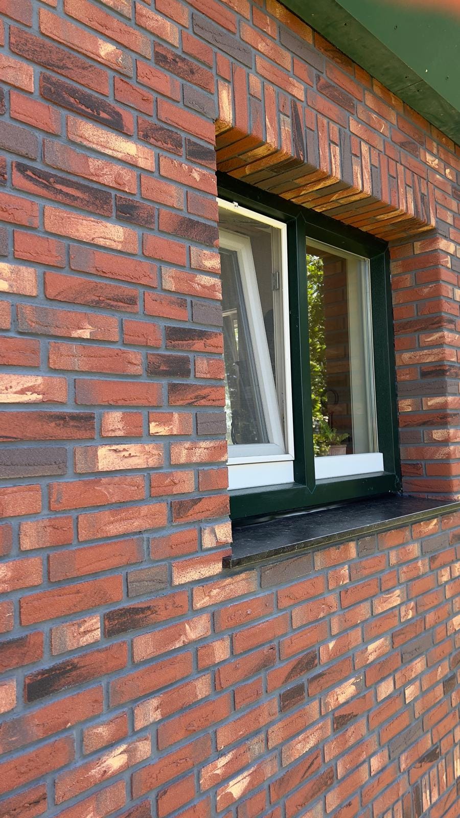 Raamdetail met roodbonte minerale steenstrips