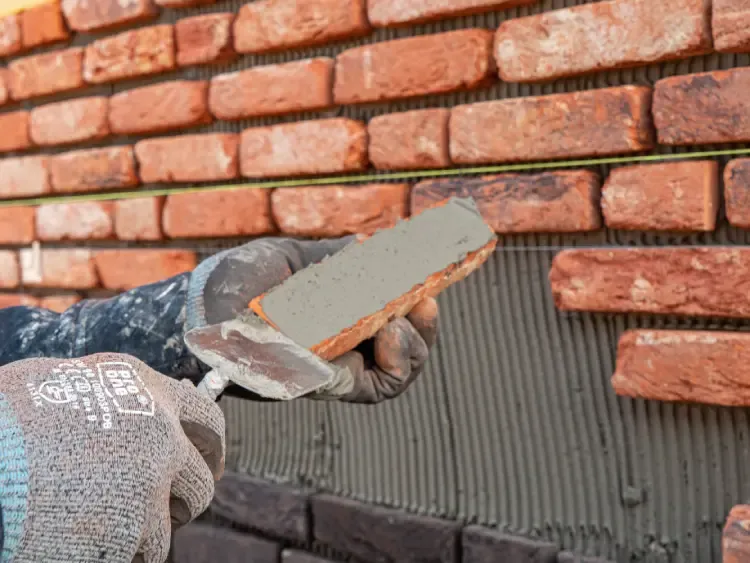 Close-up van het aanbrengen van een steenstrip op de gevel